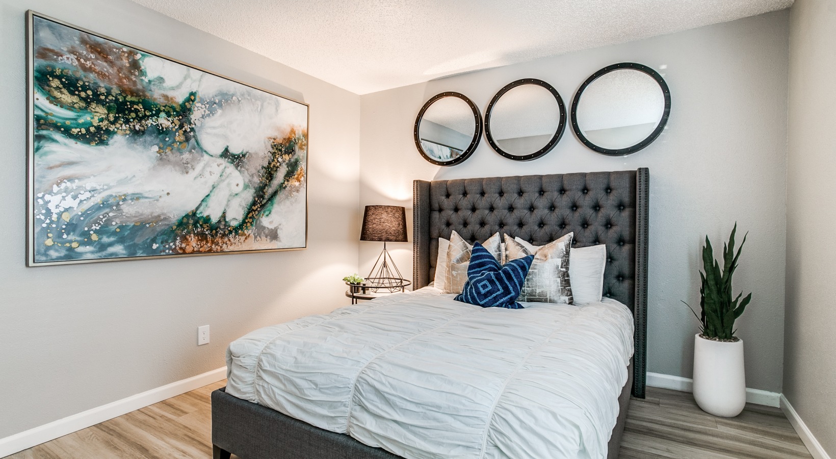 a bedroom with a bed, two nightstands and a painting at The Melville