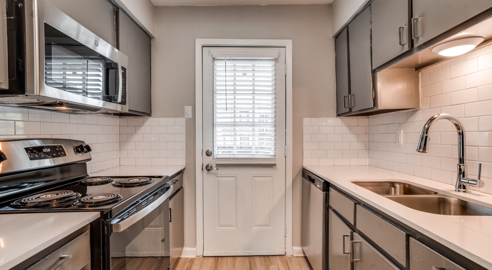 a kitchen with stainless steel appliances and a door at The Melville