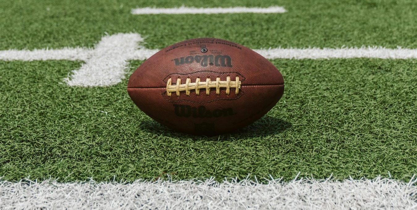 an american football sits on the field at The Melville